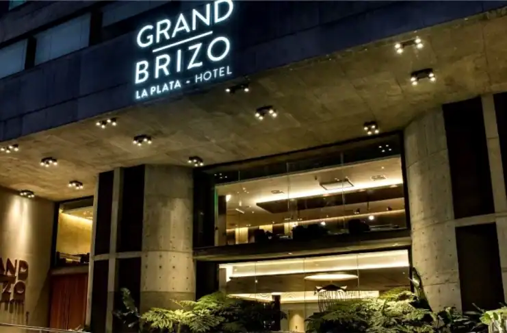 Edificio moderno del Hotel Grand Brizo en La Plata con iluminación nocturna.