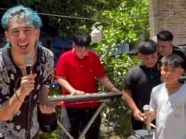 Niños y un joven con micrófonos disfrutan de actividades en un espacio verde exterior.