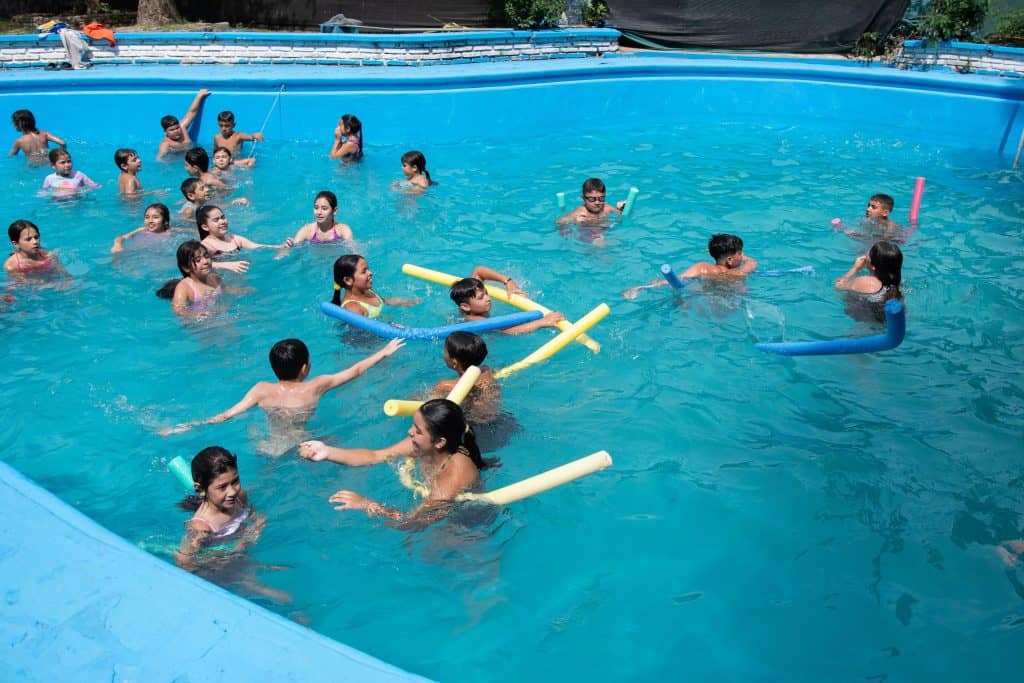 Grupo de chicos y chicas en actividades acuáticas de la Colonia de Verano municipal en Florencio Varela
