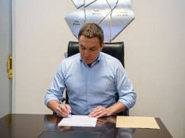 Firma digital en oficina, jefe revisando papeles importantes.