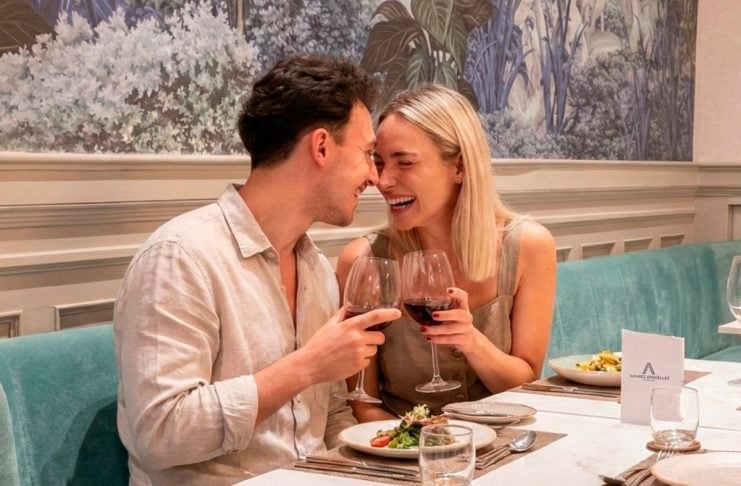 Pareja celebrando San Valentín con vino en restaurante en La Plata.