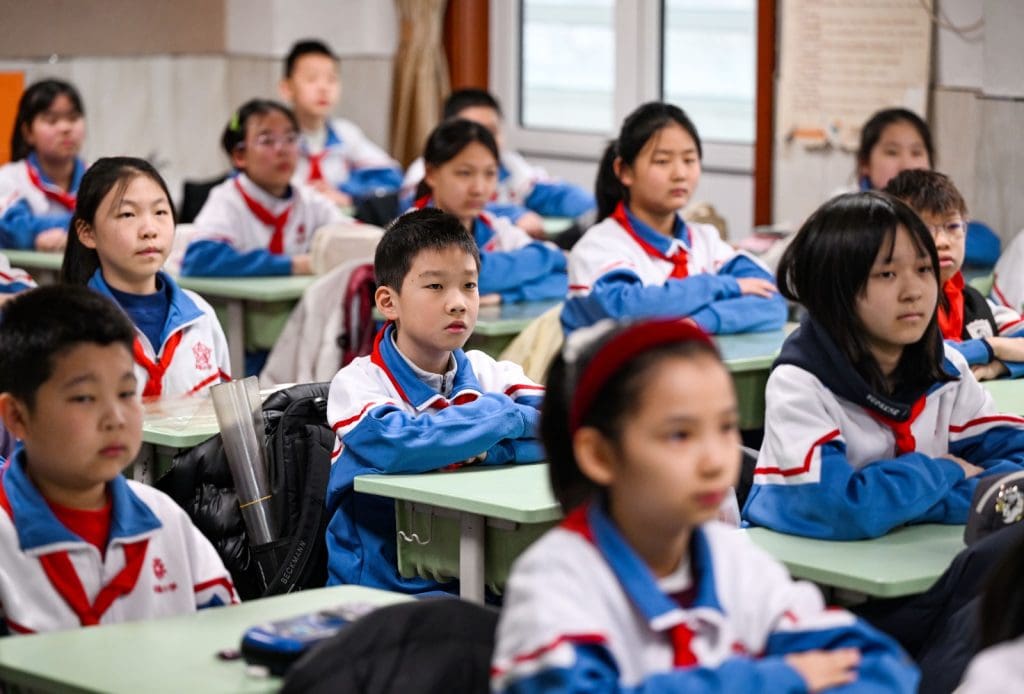 Estudiantes en aula escolar atentos durante clase con uniforme