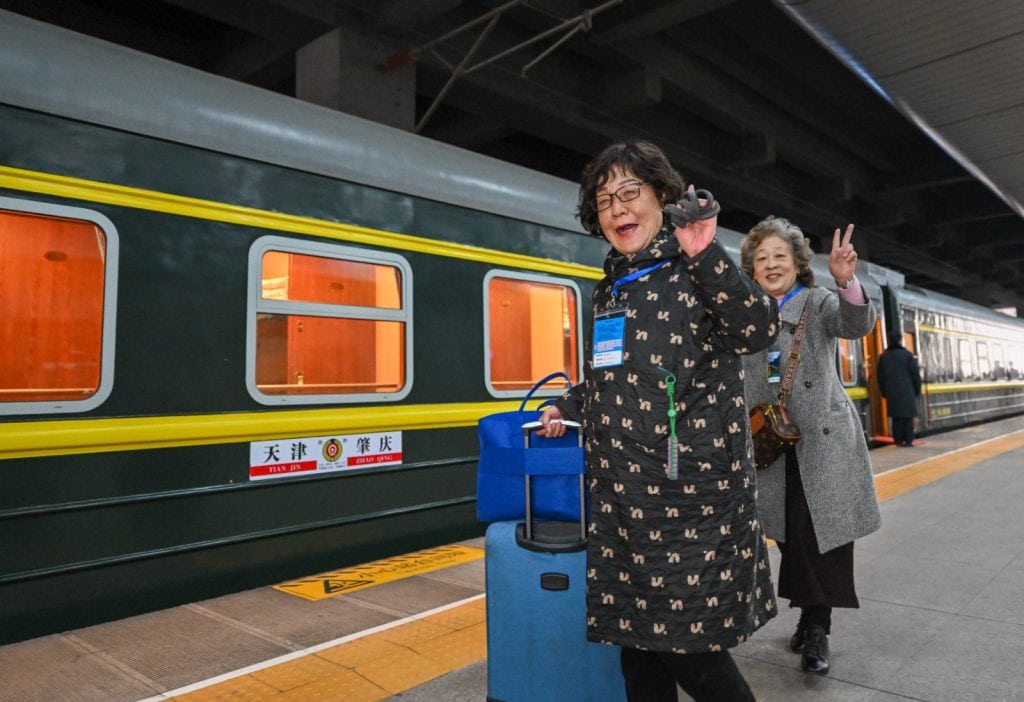 adultas mayores chinas viajando en tren con equipaje turismo tercera edad China