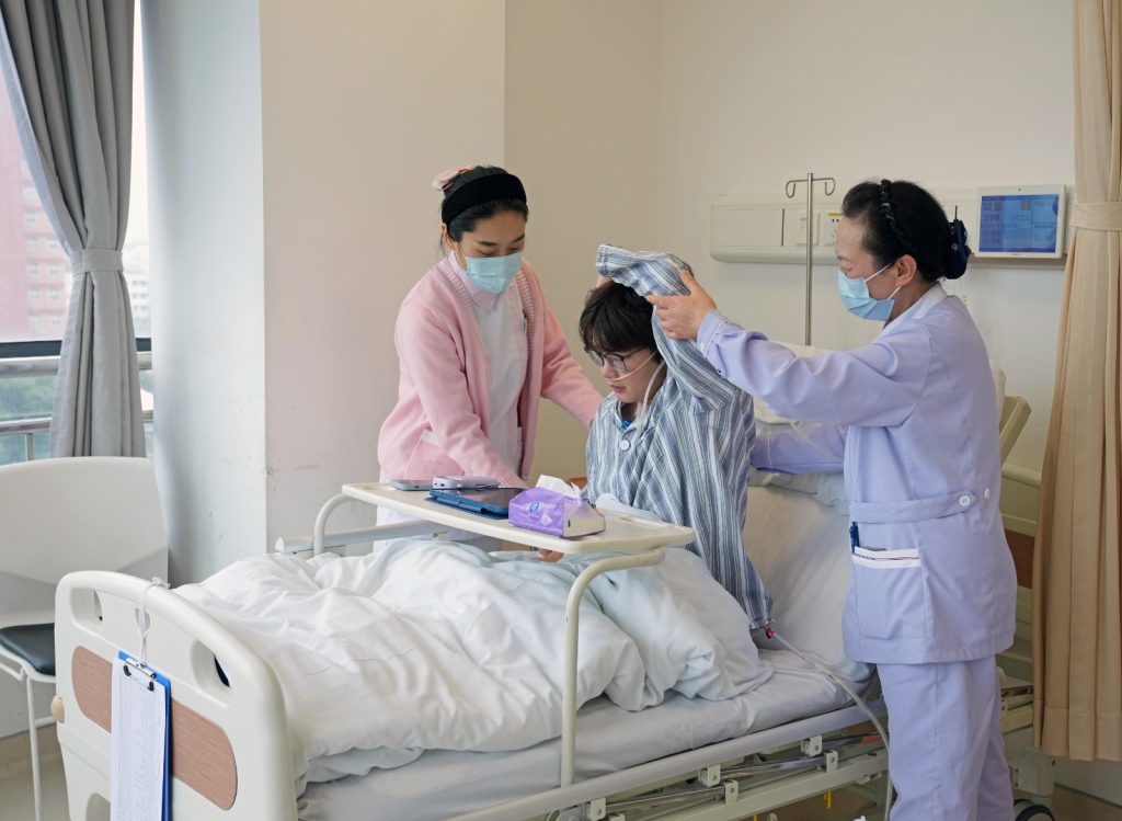 Personal de salud asiste a una paciente internada en un hospital chino.