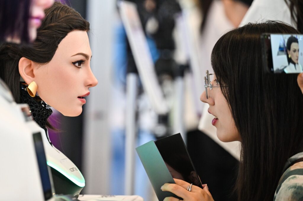 Una visitante conversa con un robot humanoide durante una exposición tecnológica en China.