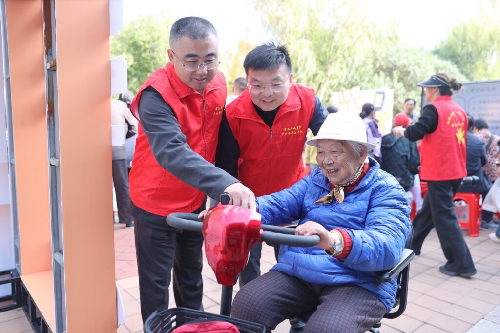 Voluntarios asisten a una mujer mayor durante una actividad comunitaria en China.